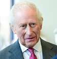 O rei Charles usando uma gravata rosa e vermelha e um terno cinza  Foto: PA Media / BBC News Brasil