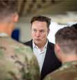 Na imagem Elon Musk, conversando com militares que estão de costas.  Foto: Xataka