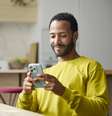 Jovem sorridente usando um smartphone.   Foto: Getty Images