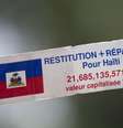Manifestante segura um cartaz em francês com os dizeres “Restituição e compensação para o Haiti” enquanto ouve o discurso do presidente francês François Hollande do lado de fora do Palácio Nacional em Porto Príncipe, Haiti, em maio de 2015. (Imagem ilustrativa)  Foto: AP - Dieu Nalio Chery / RFI
