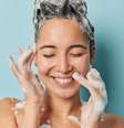 Veja as energias que combinam com seu signo - Foto: Shutterstock  Foto: imagem do rosto de uma mulher jovem tomando banho com o cabelo ensaboado em fundo azul / João Bidu - Terra Astral
