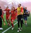 Trent Alexander-Arnold, Andrew Robertson e Caoimhin Kelleher, do Liverpool, comemoram a vitória da equipe e a confirmação do título da Premier League após a partida entre Liverpool FC e Tottenham Hotspur FC, em Anfield, em 27 de abril de 2025, em Liverpool, Inglaterra.  Foto: Carl Recine/Getty Images