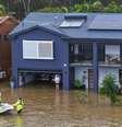 Equipes de resgate ajudam uma moradora ilhada pelas enchentes em sua casa em Port Macquarie, ao norte de Sydney, Austrália  Foto: AP - Lindsay Moller / RFI