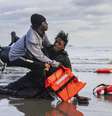 Foto ilustrativa: Um migrante sudanês na areia após deixar o barco de um traficante, que foi esvaziado por policiais franceses para impedir a travessia da Mancha. A cena aconteceu na praia de Gravelines, perto de Dunkerque, no norte da França, em 26 de abril de 2024.  Foto: AFP - SAMEER AL-DOUMY / RFI