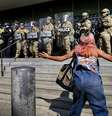 Manifestante se posiciona diante de barreira das forças de segurança durante protesto em Los Angeles na segunda-feira (9).  Foto: AP - Eric Thayer / RFI