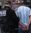 Dois policiais colocam homem algemado em carro da polícia  Foto: Getty Images / BBC News Brasil