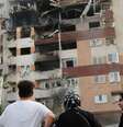 Pessoas observam um prédio danificado após ataques israelenses em Teerã, no Irã  Foto: Reuters / BBC News Brasil