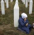 Uma muçulmana bósnia presta homenagem no túmulo de um /parente, vítima do genocídio de Srebrenica. 10/07/25.  Foto: AP - Armin Durgut / RFI