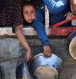 Uma menina palestina encostada em um muro, ao lado de outras pessoas, segurando uma tigela de metal, à espera da distribuição de sopa de lentilha na Cidade de Gaza, no norte da Faixa de Gaza  Foto: AFP / BBC News Brasil