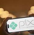 Em imagem de ilustração, um smartphone exibe o logotipo do Pix, o sistema de pagamento instantâneo gratuito do Brasil desenvolvido pelo Banco Central.  Foto: AFP - MAURO PIMENTEL / RFI