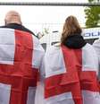 Três pessoas de costas envoltas na bandeira da Inglaterra  Foto: PA Media / BBC News Brasil