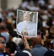 Fieis reunidos na Praça de São Pedro seguram uma imagem do Papa Leão XIV para lhe desejar um feliz aniversário, durante sua oração do Angelus, no Vaticano, em 14 de setembro de 2025.  Foto: AFP - FILIPPO MONTEFORTE / RFI