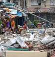 Moradores locais permanecem nas ruas perto dos escombros de prédios danificados em meio a tremores secundários frequentes, após um terremoto de magnitude 6,9 ​​que sacudiu partes da ilha, na Cidade de Bogo, Cebu, Filipinas.  Foto: Daniel Ceng/Anadolu via Getty Images
