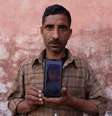 Um pai segura uma foto de seu filho, que é uma das pelo menos 12 crianças com menos de cinco anos de idade, cujas mortes supostamente foram ligadas a um xarope para tosse em Jammu  Foto: Reuters / BBC News Brasil