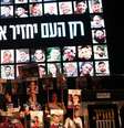 Pessoas seguram fotos de reféns israelenses enquanto se reúnem na "Praça dos Reféns" em Tel Aviv, para comemorar o acordo assinado entre Israel e o Hamas para uma troca de reféns por prisioneiros, baseada em um plano de 20 pontos proposto pelo presidente norte-americano Donald Trump, em 11 de outubro de 2025.  Foto: AFP - JACK GUEZ / RFI