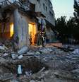 Uma idosa caminha com a ajuda de um socorrista em meio aos escombros de um prédio residencial danificado após um ataque de drone russo em 12 de junho de 2025 em Kharkiv, Ucrânia  Foto: Global Images Ukraine / GettyImages