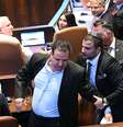 O parlamentar israelense Ayman Odeh é escoltado para fora após segurar uma placa com os dizeres "Reconhecer a Palestina" durante um discurso do presidente dos EUA, Donald Trump, no parlamento israelense, o Knesset, em 13 de outubro de 2025, em Jerusalém.  Foto: Saul Loeb - Pool/Getty Images
