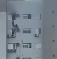 A mulher se sustentou sobre uma caixa de ar condicionado para retirar a mãe e a criança do apartamento  Foto: Reprodução