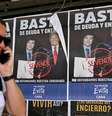 Homem passa diante de um cartaz com os presidentes Javier Milei e Donald Trump, em Buenos Aires, em 14 de outubro de 2025.  Foto: © Luis ROBAYO / AFP / RFI