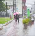 Pedestres se protegem da chuva em Venâncio Aires, no Rio Grande do Sul, na sexta-feira, 7, durante passagem de um ciclone extratropical pela região  Foto: LEANDRO OSÓRIO/ATO PRESS/ESTADÃO CONTEÚDO