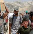 Homem palestino carrega caixa de comida obtida no ponto de passagem de Zikim, no norte da Faixa de Gaza, em 1º de agosto de 2025.  Foto: AFP - BASHAR TALEB / RFI