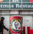 Japonesas passam pelo restaurante KFC em Tóquio, onde a tradição na noite de Natal é comer frango frito.  Foto: AFP - YUICHI YAMAZAKI / RFI