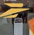 O símbolo do serviço postal francês, La Poste, na vitrine de uma de suas agências.  Foto: © AFP / RFI