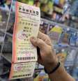 Um cliente segura um bilhete da loteria Powerball após comprá-lo em Miami  Foto: Imagem de arquivo/Joe Raedle/Getty Images