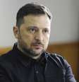 Volodymyr Zelensky sentado em uma cadeira, vestindo uma camisa preta e olhando para a direita da câmera. Ele está sentado diante de uma bandeira da Ucrânia.
  Foto: BBC News Brasil