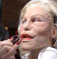 Alexis Stone na preparação para o desfile: rosto deformado com prótese e maquiagem para criticar o culto à beleza perfeita  Foto: Reprodução