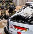 Forças de segurança israelenses e equipes de resgate perto de um veículo destruído no local de um ataque iraniano que atingiu um bairro residencial em Bat Yam, ao sul de Tel Aviv, em 9 de março de 2026.  Foto: AFP - JACK GUEZ / RFI
