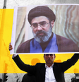 Imagem tratada mostra um homem de terno escuro e camisa branca segurando um cartaz do novo líder supremo do Irã, Mojtaba Khamenei. Um retângulo amarelo foi interposto entre o homem e o cartaz, com outras figuras ao fundo  Foto: Getty Images, BBC / BBC News Brasil