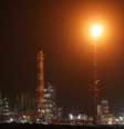 Chamas de gás excedente iluminam a refinaria de Haifa, no norte de Israel, na noite desta quinta-feira (19), em meio ao aumento das tensões na região.  Foto: © Odd Andersen / AFP / RFI