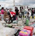 Ativistas da flotilha Nuestra América e autoridades cubanas descarregam ajuda humanitária do navio "Granma 2.0" no porto de Havana, em 24 de março de 2026.  Foto: AFP - JORGE LUIS BANOS / RFI