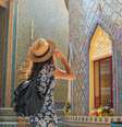 Mulher viajante usando vestido florido e chapéu no templo Wat Ratchabophit em Bangkok em um dia de verão  Foto: Getty Images / BBC News Brasil