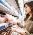Mulher observa pacotes de frango no supermercado  Foto: Getty Images / BBC News Brasil