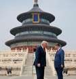 Os presidentes Trump e Xi estão em pé, frente a frente e com a cabeça levemente inclinada, diante de uma escadaria ornamentada que leva a um templo chinês decorado em tons de azul, verde, vermelho e dourado.
  Foto: Reuters / BBC News Brasil
