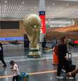 Passageiros passam por réplica gigante do troféu da Copa do Mundo no Aeroporto Internacional da Cidade do México 
 18 de maio de 2026    REUTERS/Henry Romero  Foto: Reuters