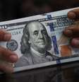 Um funcionário segura notas de dólar americano em uma casa de câmbio em Jacarta, na Indonésia (REUTERS/Willy Kurniawan)  Foto: Reuters