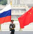 Militares seguram bandeiras da Rússia e da China durante viagem de Putin a Xi  Foto: ANSA / Ansa - Brasil