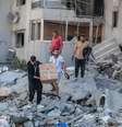 Moradores inspecionam os danos no local de um ataque israelense noturno na cidade de Tiro, no sul do Líbano, em 23 de maio de 2026.  Foto: REUTERS - Aziz Taher / RFI