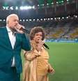 Belo e Alcione cantam o hino nacional brasileiro durante jogo do Brasil no Maracanã.  Foto: Reprodução de 'Brasil x Panamá' (2026)/TV Globo / Estadão