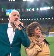 Belo e Alcione cantaram o Hino do Brasil antes do jogo da Seleção Brasileira no Maracanã. Foto: Reprodução/TV Globo / Purepeople