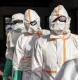 Trabalhadores fazem fila para desinfetar seus equipamentos de proteção no Hospital Geral de Mongbwalu durante o surto de ebola  Foto: Michel Lunanga/Getty Images