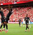Jonathan David celebra um dos três gols que marcou na goleada sobre o Catar com Stephen Eustaquio - Foto: Fran Santiago/Getty Images / Jogada10
