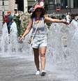 Mulher caminha entre fontes em Gênova para se refrescar de calor  Foto: ANSA / Ansa - Brasil