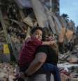 Mulher carrega criança no colo diante de prédio colapsado em Caracas  Foto: ANSA / Ansa - Brasil