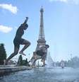 Pessoas mergulham na Fonte do Trocadéro, perto da Torre Eiffel, durante uma onda de calor em Paris, em 22 de junho de 2026.  Foto: RFI
