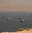 Dezenas de embarcações cruzam o Estreito de Ormuz, cercado por montanhas rochosas, visto da península de Musandam, em Omã.
  Foto: Reuters / BBC News Brasil