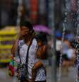 Extenso, Brasil sofre com dezenas de ondas de calor ao longo do ano. Na imagem, mulher se refresca em chafariz de Porto Alegre. (15/12/2023) Foto: RFI